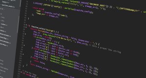 JavaScript code displayed on a dark monitor, showing colorful syntax highlighting.